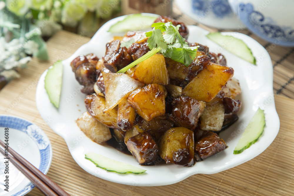 Vietnamese braised cube of pork with pineapple on white plate on the table in restaurant Vietnamese braised cube of pork with pineapple on white plate on the table in restaurant