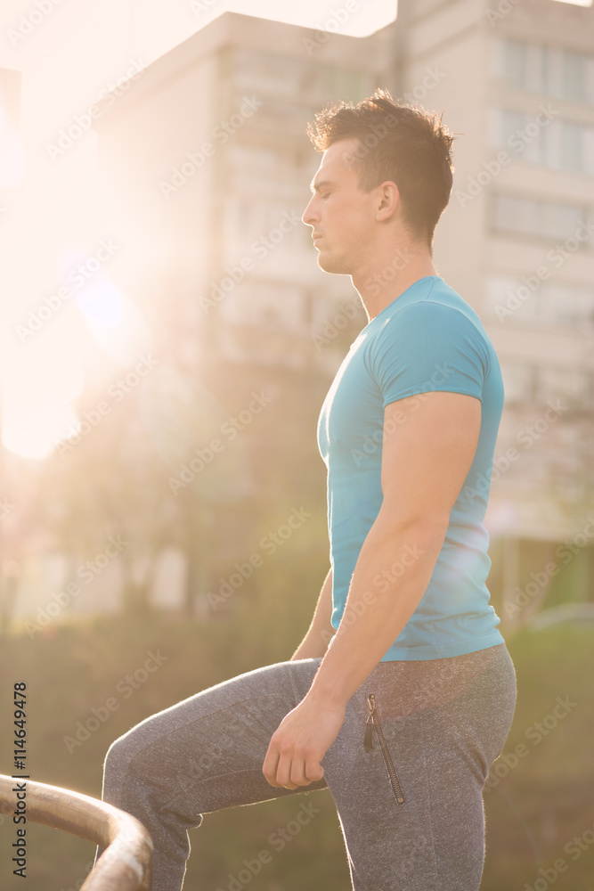 Fototapeta premium portrait of handsome jogging man while relaxing and take break a