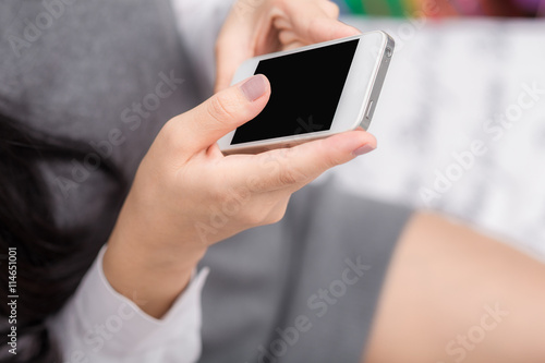 Beautiful black asian woman using on her phone laying in her bed