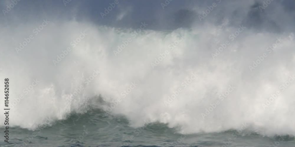A series of glassy green waves breaking in clouds of foam close to the camera A series of glassy green waves breaking in clouds of foam close to the camera