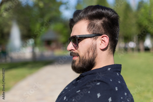 Young man relaxing on park bench on a summers day