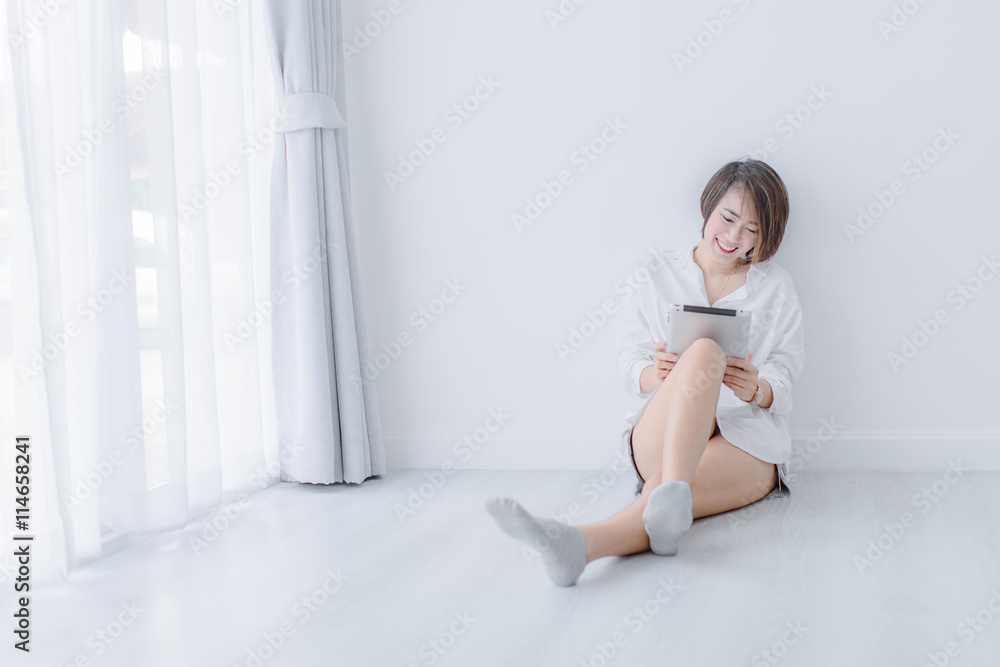 Beautiful young asian woman wearing white shirt and using tablet Beautiful young asian woman wearing white shirt and using tablet