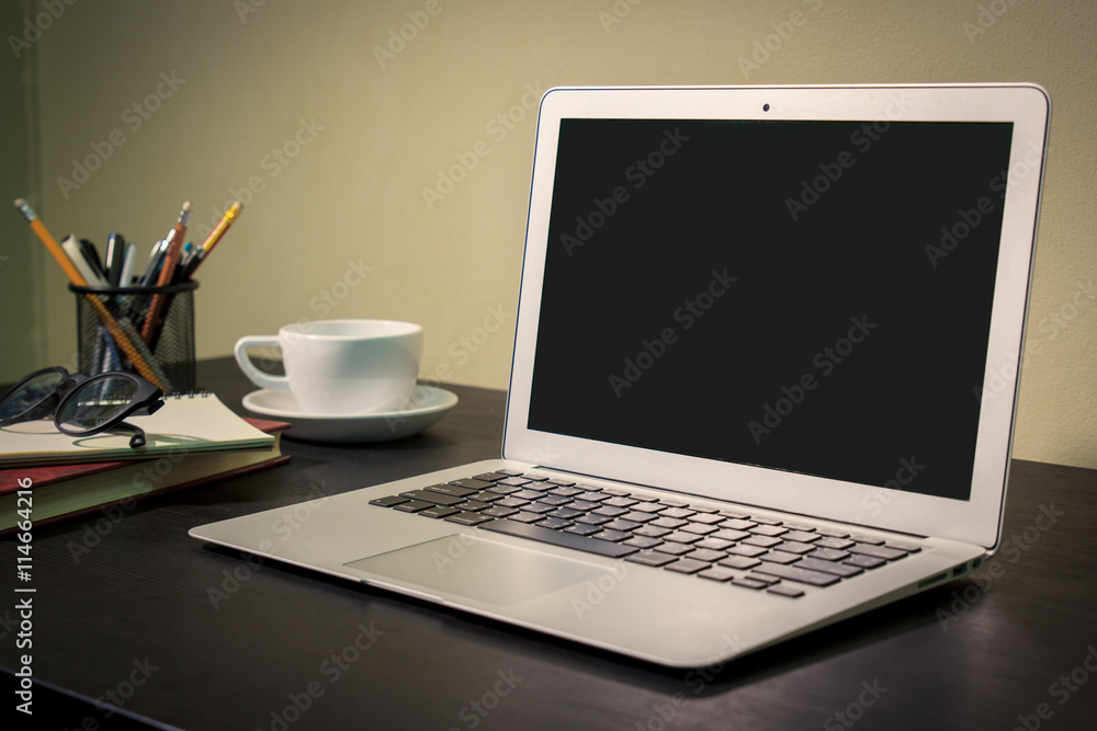 Laptop with blank screen on table. Laptop with blank screen on table.