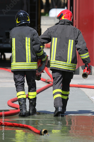 firefighters carry the hydrant and hose pipes after put off the photo