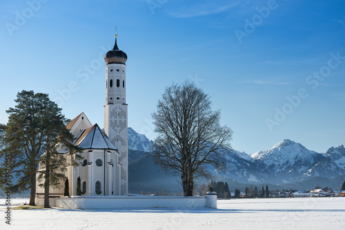 St. Coloman church at midday on a sunny winter day with snow 