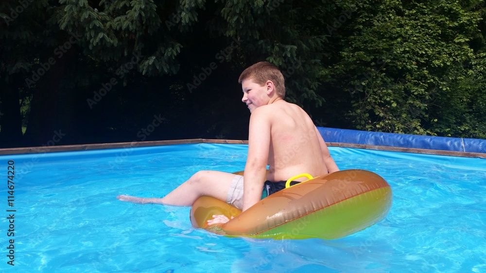 Junge hat Spaß beim Baden im Pool mit Schwimmring