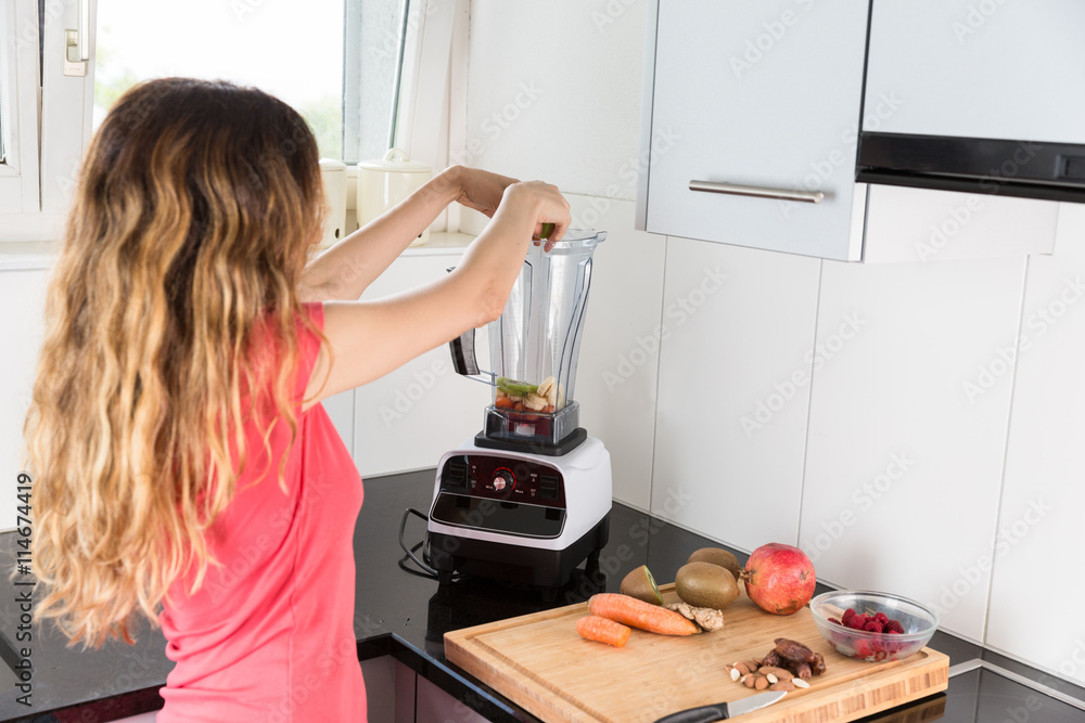 Woman making smoothie in the kitchen