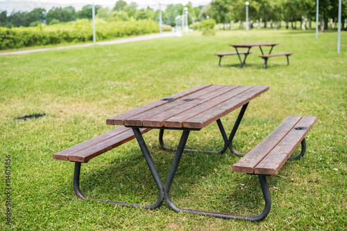 Wooden picnic table and benches in park