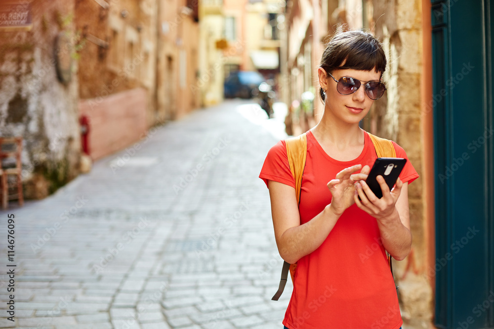 woman tourist walking in the old town, and talking by phone, Crete, Greece