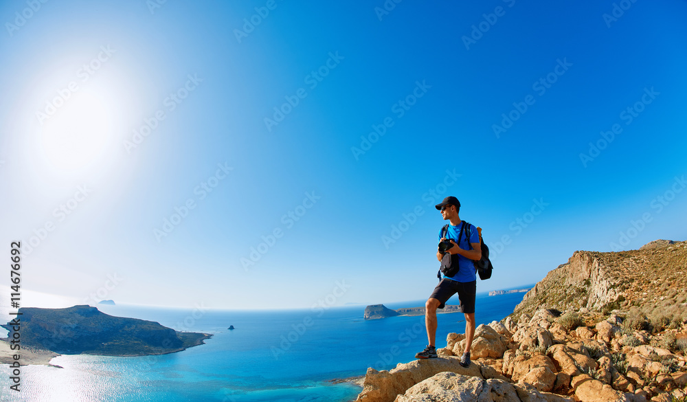 Fototapeta premium panoramic view on Balos beach, Crete, Greece. Man, traveller and photographer stands on the cliff