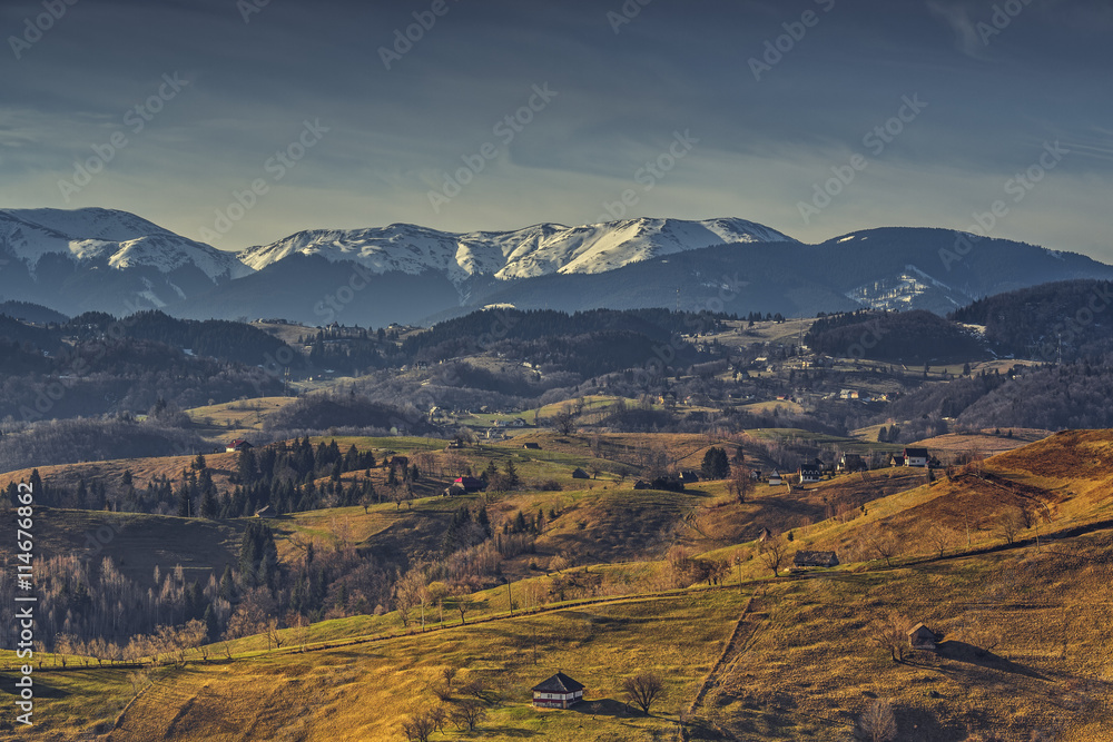 Fototapeta premium Rural landscape with traditional Romanian neighborhoods in the valleys of Bucegi mountains uphill in Sirnea village, Brasov county, Romania.