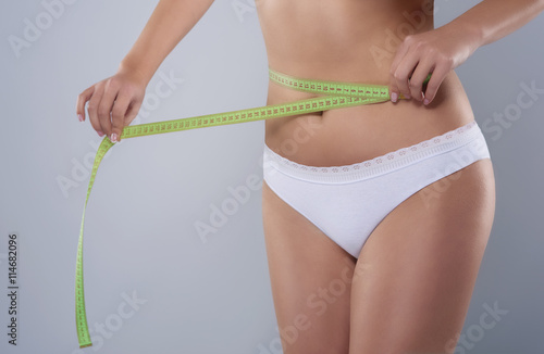 Part of woman measuring the waist