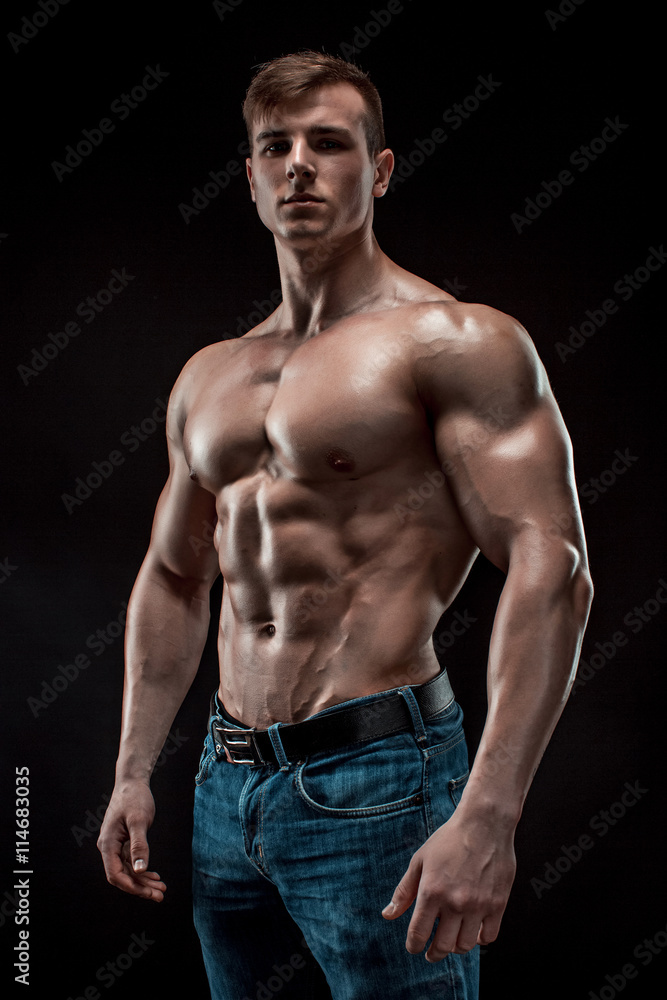 Muscular bodybuilder guy doing posing over black background Muscular bodybuilder guy doing posing over black background