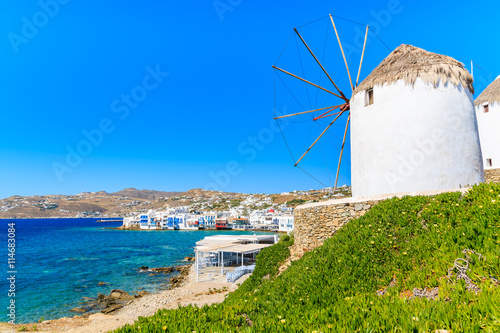 White traditional windmill overlooking Mykonos port, Cyclades islands, Greece