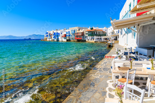Chairs with tables in typical Greek taverna in Little Venice part of Mykonos town, Mykonos island, Greece photo