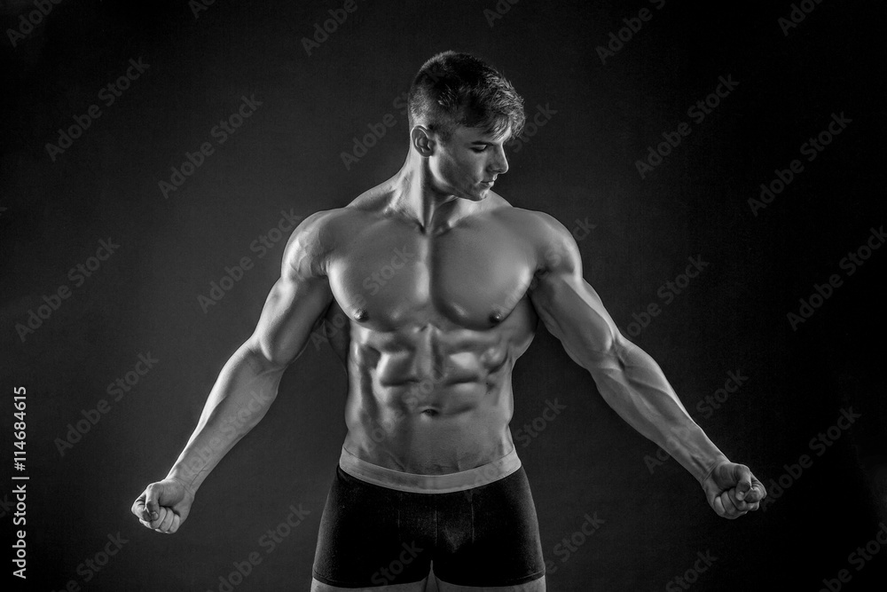 Muscular bodybuilder guy doing posing over black background Muscular bodybuilder guy doing posing over black background
