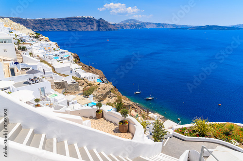 Steps to beautiful Oia village with typical white architecture and view of caldera, Santorini island, Greece