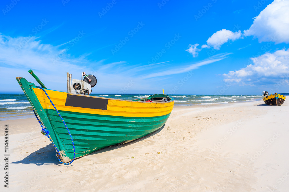 Colorful fishing boat on sandy Baltic Sea beach, Poland