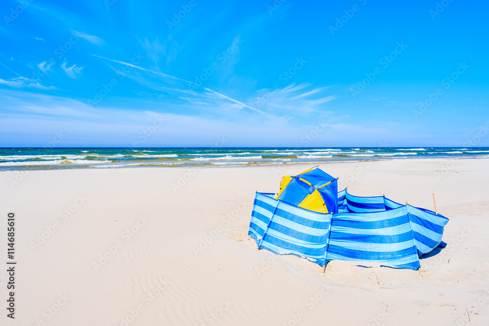 A wind breaker with tent on white sand beach in Debki coastal village, Baltic Sea, Poland