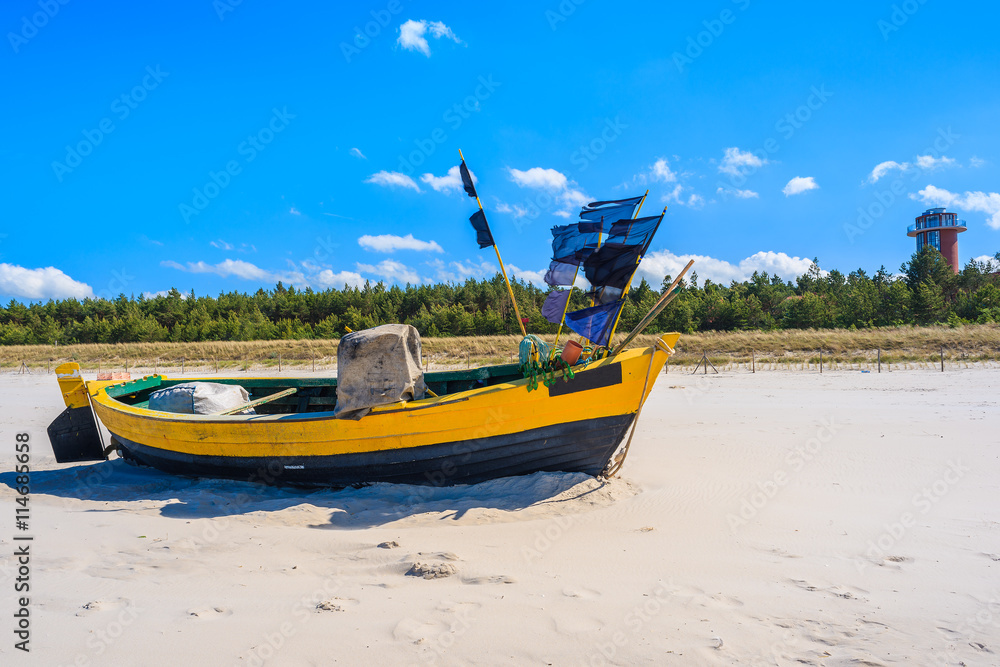 Fototapeta premium Colorful traditional fishing boat on sandy Baltic Sea beach in Debki, Poland