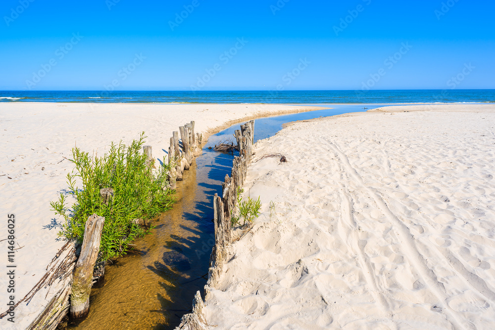 A view of beautiful beach with small river estuary to Baltic Sea in Lubiatowo village, Poland