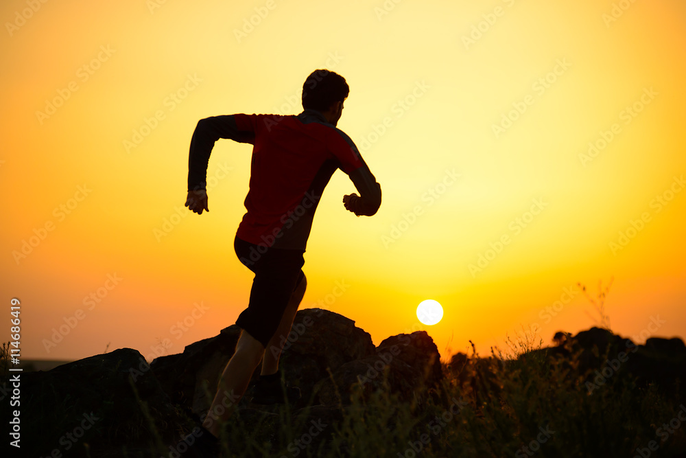 Young Sportsman Running on the Rocky Mountain Trail at Sunset. Active Lifestyle
