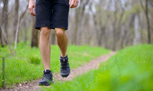 Close-up of Sportsman's Legs Walking on the Trail in the Wood. Active Lifestyle