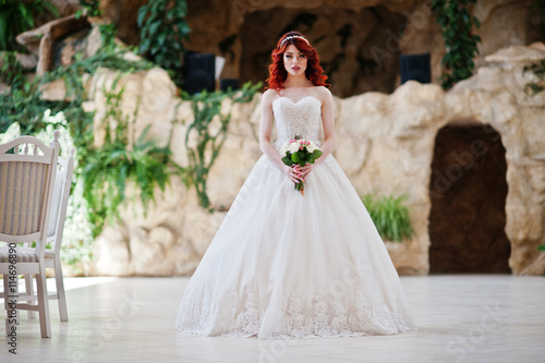 Charming red-haired bride with wedding bouquet at hand posed at © AS Photo Family