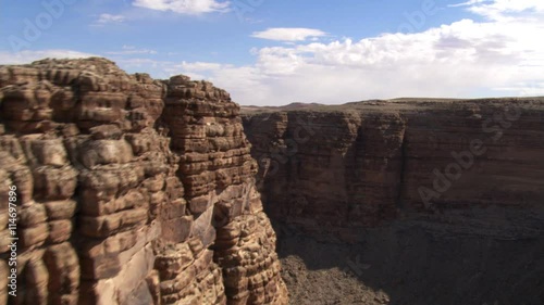 Flying across rock formation in desert canyon photo