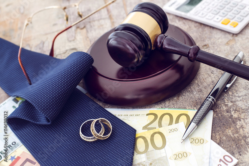 Family law concept, gavel, rings and money on wooden table