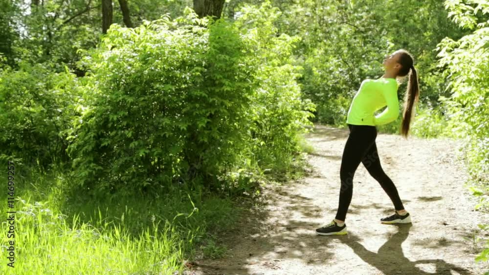 Young slim pretty woman doing fitness exercises in the park near a forest. full hd Young slim pretty woman doing fitness exercises in the park near a forest. full hd