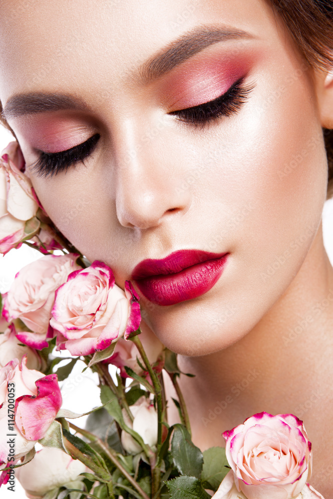 Portrait of young beautiful woman with stylish make-up and colorful roses around her face Portrait of young beautiful woman with stylish make-up and colorful roses around her face