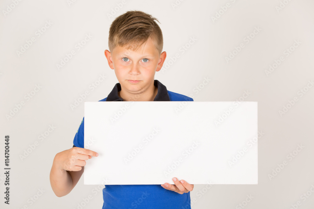 junger Mann in kurzen Hosen / Freizeit Outfit hält weißes Schild mit Platz für Text junger Mann in kurzen Hosen / Freizeit Outfit hält weißes Schild mit Platz für Text