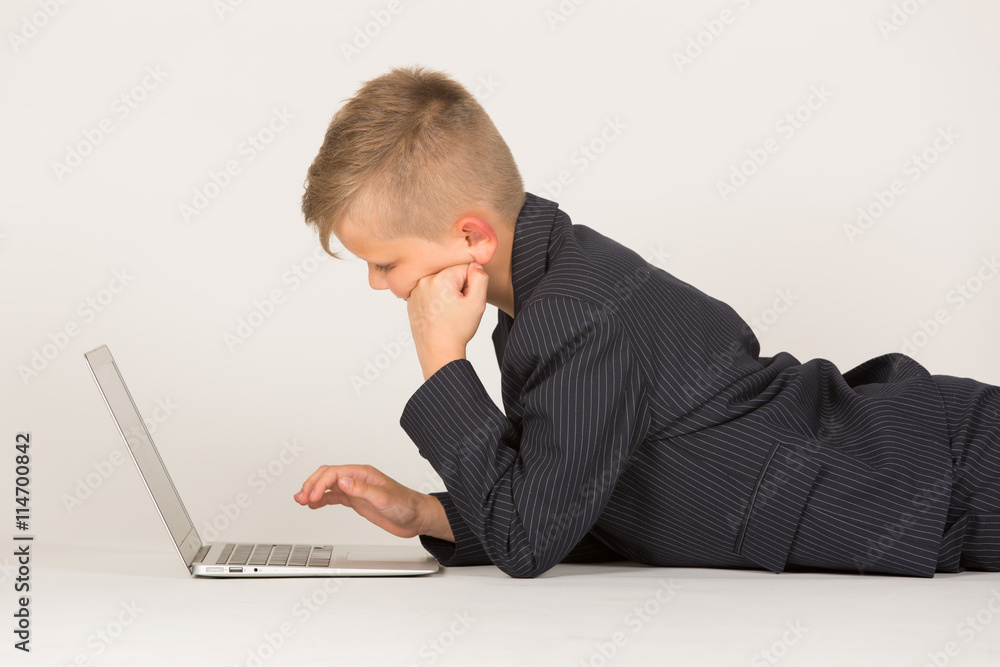 Kind / junger Mann in Anzug liegt vor Laptop PC Computer Kind / junger Mann in Anzug liegt vor Laptop PC Computer