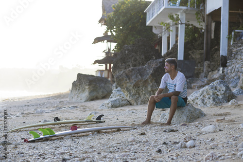 Indonesia, Bali, surfer sitting on the beach photo