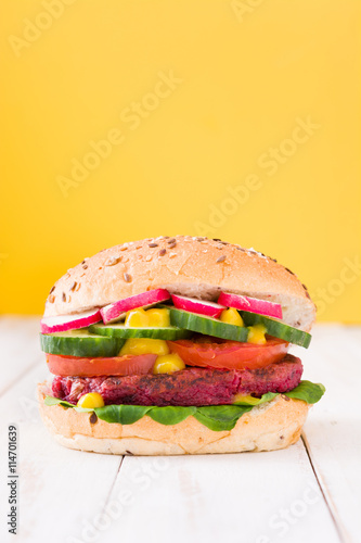 Veggie beet burger on yellow background