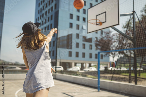 Young woman aiming at basketball hoop photo