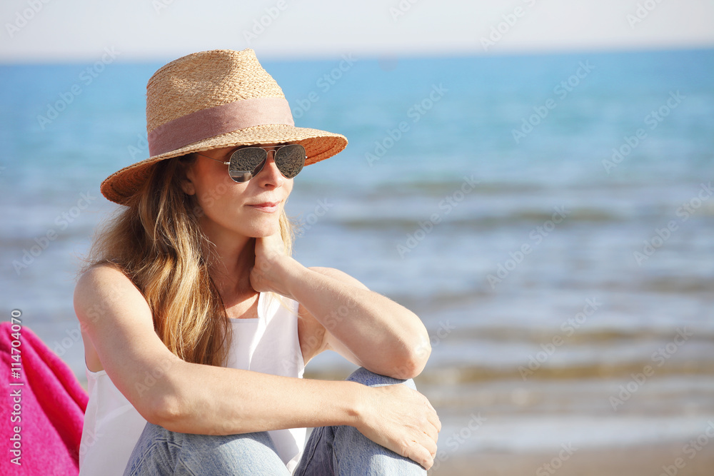 Happy middle age woman relaxing on the beach. Happy middle age woman relaxing on the beach.