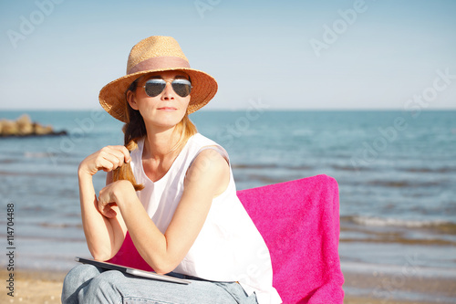 Ejoying summer on seaside. Beautiful woman relaxing on the beach.