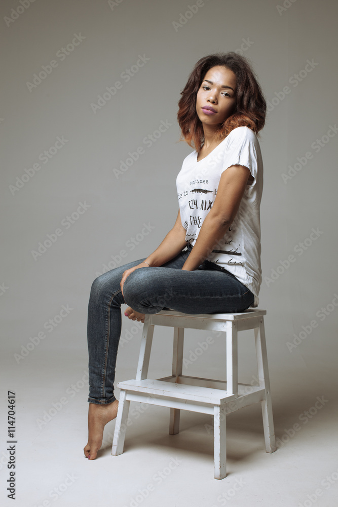 Elegant beautiful African American woman sitting in a contemporary chair Elegant beautiful African American woman sitting in a contemporary chair