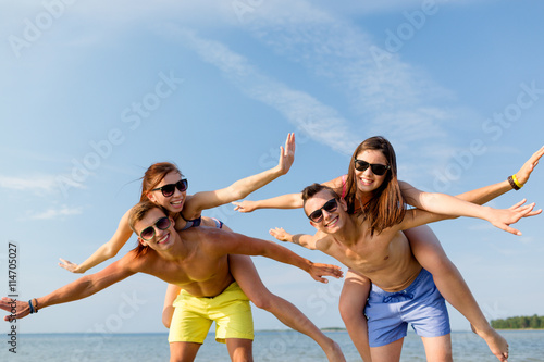 smiling friends having fun on summer beach