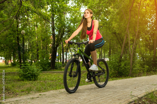 Happy girl cyclist riding on a mountain bike outside