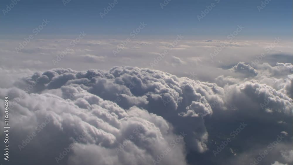 Flying alongside lumpy cloud mass, passenger POV Flying alongside lumpy cloud mass, passenger POV