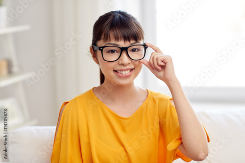 happy asian young woman in glasses at home