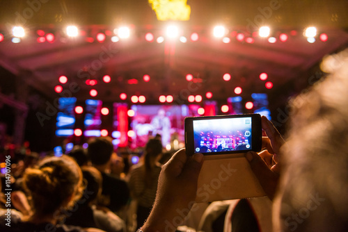 People holding their smart phones shooting video or photo.