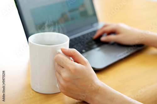 Businesswoman using tablet computer-net book and drinking coffee