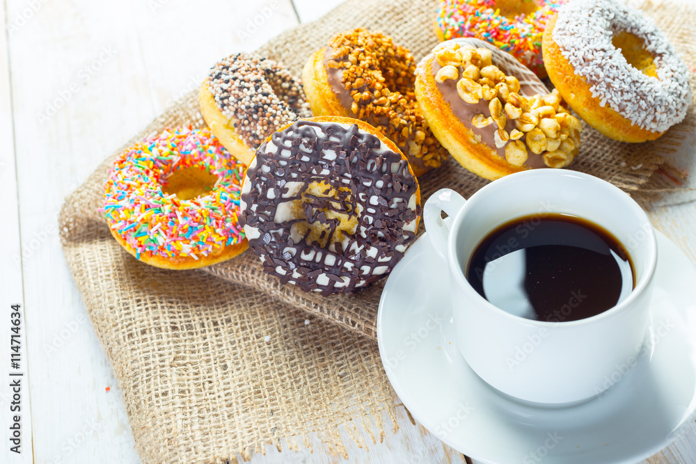 Donuts and coffee on a white wood background. Donuts and coffee on a white wood background.