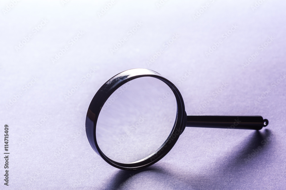 Magnifier on blue background close up Magnifier on blue background close up