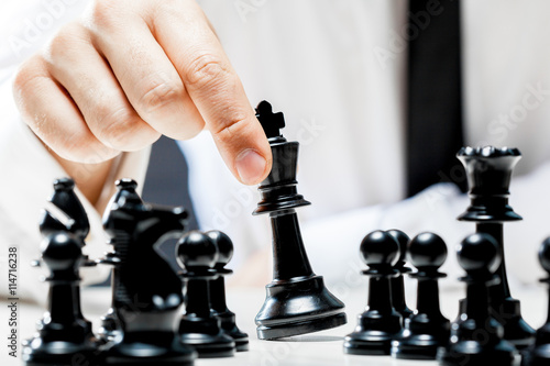 Photo Hand of businessman playing chess