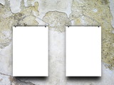 Close-up of two square blank frames hanged by clothes hanger against weathered scratched concrete wall background